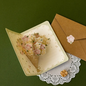 3D pop-up flower greeting card with kraft envelope and sticker on green background