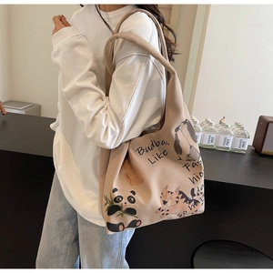 Detailed close-up of beige tote bag featuring cute cartoon animal prints and typography