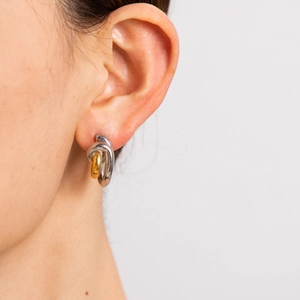 Detailed close-up of mixed gold and silver stainless steel C-shaped twisted earrings
