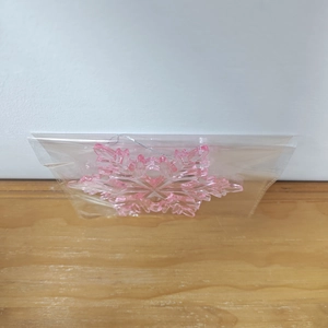 Pink acrylic snowflake ornament with silver string in transparent packaging