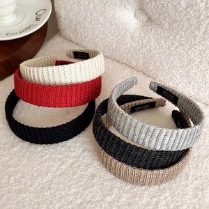 Close-up of assorted knit headbands in neutral colors with soft woven texture details
