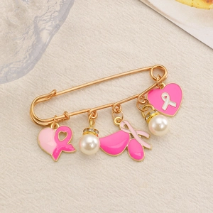 Détail d'une broche ruban rose contre le cancer du sein avec des cœurs et des perles