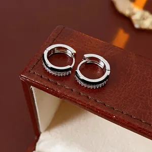 Silver geometric hoop earrings with black enamel and zircon pavé on leather display
