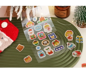 Detailed view of Christmas PET stickers with Santa and reindeer on a green tray