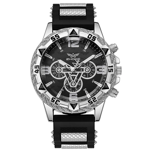 Détail d'une montre à quartz avec lunette noire et bracelet silicone à inserts métal