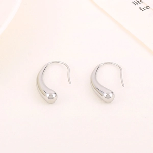 Macro shot of silver teardrop earrings with a polished metallic finish and smooth lines