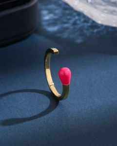 Macro detail of gold open ring with a creative pink matchstick head design feature