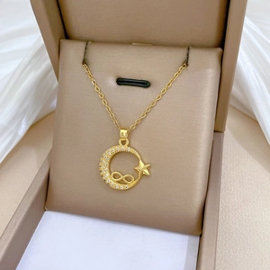 Macro shot of gold moon and star pendant necklace with crystals in a gift box