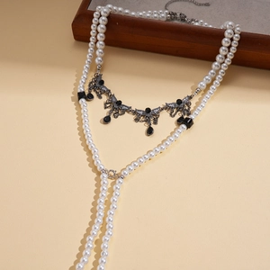 Detail view of multi-layer pearl necklace with vintage black gemstone wing pendant