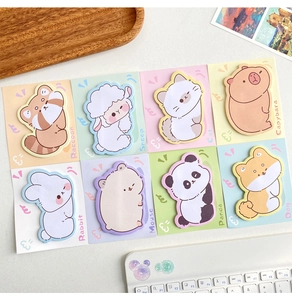 Flat lay of eight cute animal-shaped sticky notes on a clean desk with office props