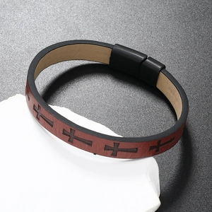Detail of red-brown braided leather bracelet with black cross patterns and magnetic clasp