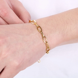 Close-up of gold stainless steel paperclip chain bracelet on a person's wrist