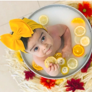 Close-up of bright yellow double-layer bow headband for baby on a creative lemon background