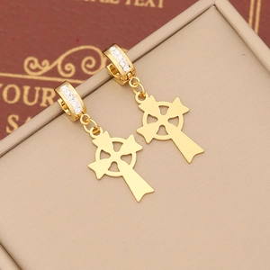 Macro shot of gold cross earrings with sparkling white cubic zirconia stones