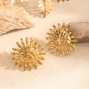 Elegant gold sunburst earrings made of stainless steel displayed on a natural beige backdrop