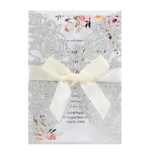 Elegant laser cut silver glitter wedding invitation with beige ribbon and floral inner card