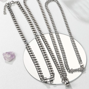 Detailed shot of silver dumbbell pendant on Cuban chain with a high-polish finish