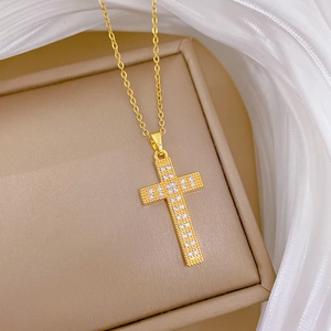 Luxurious gold cross pendant necklace with sparkling cubic zirconia on silk fabric