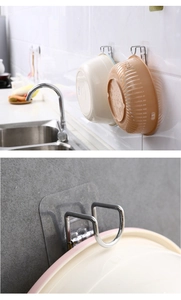 Detail of wall-mounted stainless steel washbasin hook showing U-shaped design and mounting