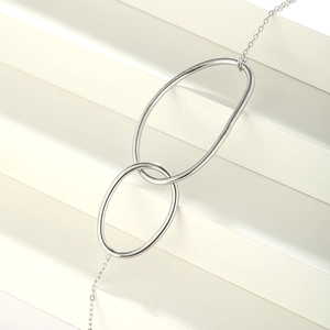 Macro shot of minimalist silver stainless steel double rings with interlocking geometric link