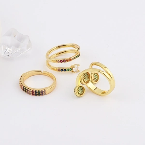 Detailed view of three gold-plated rings set with colorful zircons and crystals