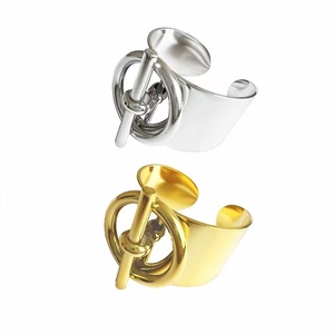 Gold and silver stainless steel open bangles with T-bar and ring design on white backdrop