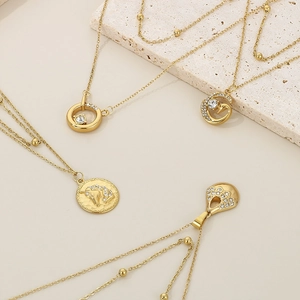 Detail view of 18K gold-plated layered necklaces with diamond accents and star pendants