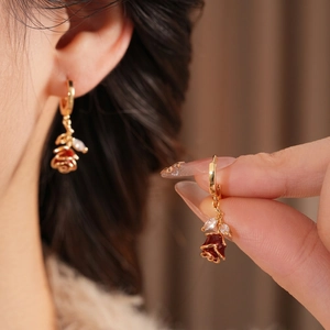 Élégantes boucles d'oreilles dorées avec roses en émail rouge et cristaux de zircone