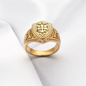 Gros plan détaillé d'une bague bouclier croix dorée avec gravures vintage latérales