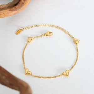 Elegant gold-plated stainless steel heart bracelet with zircon crystals on a white surface