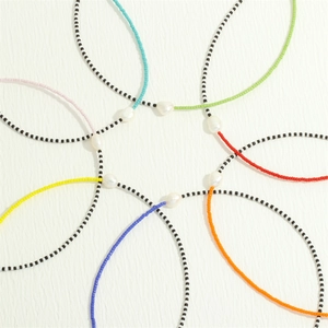 Flat lay of colorful Bohemian beaded necklaces with natural freshwater pearls on white