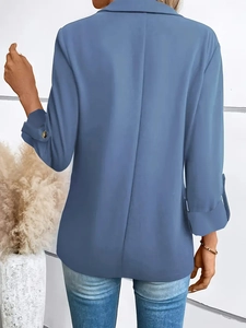 Back view of a blue long sleeve blazer showing the center pleat and refined metal buttons
