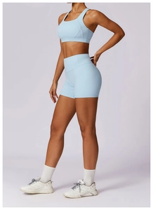 Detailed side view of high-elastic light blue sports bra and high-waist fitness shorts