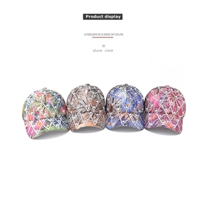 Detail of four baseball caps with rhinestones, pearls and colorful printed patterns
