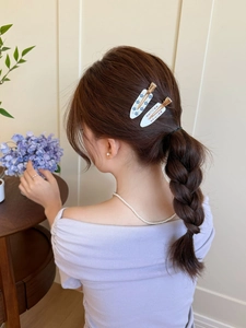 Détails de barrettes françaises en acétate avec motifs floraux sur cheveux tressés