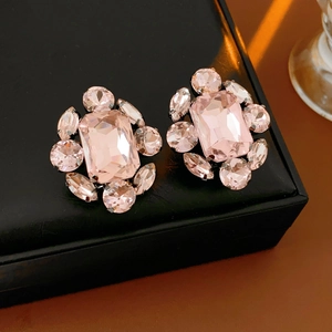 Vue macro de boucles d'oreilles fleurs en cristal rose avec gemmes facettées sur métal