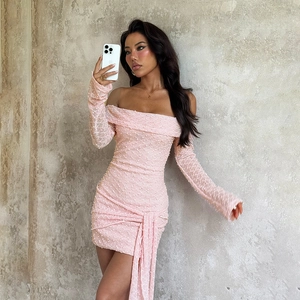 Détail de la robe mini rose à épaules dénudées avec tissu texturé et franges à la taille