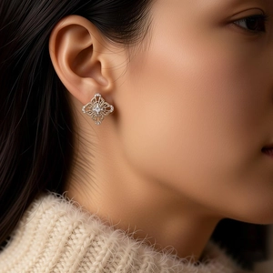Macro view of geometric silver earrings with cubic zirconia on a model's ear