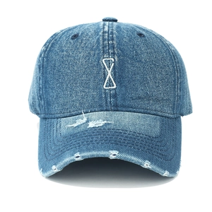 Close-up of distressed blue denim baseball cap with white geometric embroidery detail