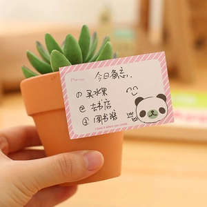 Cute cartoon panda sticky notes with pink stripes on a wooden desk with a succulent
