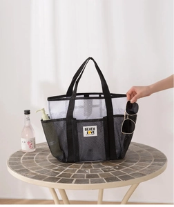 Mesh beach bag detail showing multi-pocket storage for toiletries and sunglasses
