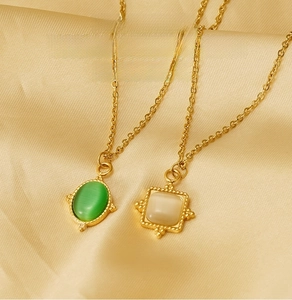 Detailed shot of 18K gold-plated stainless steel necklaces with emerald and white natural stones