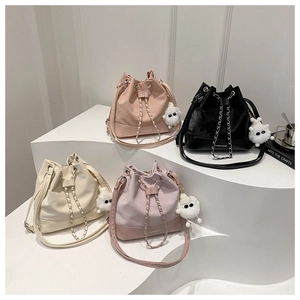 Collection of four stylish drawstring bucket bags in pastel colors with plush charms