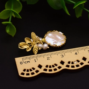 Baroque pearl drop earrings in leaf design with wood ruler measurement reference