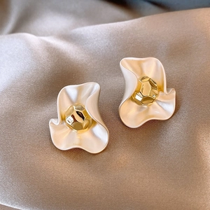 Detailed view of vintage enamel petal earrings with a gold center on champagne silk