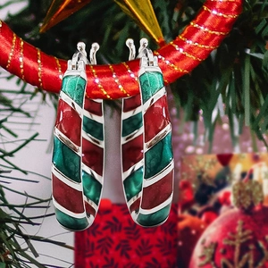 Festive candy cane hoop earrings with red, green and white stripes on Christmas tree branch