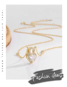Macro detail of gold S925 silver heart lock necklace with zircon stones and fine chain