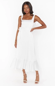 Detail of adjustable shoulder bow ties on a white satin ruffled midi dress