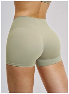 Dettaglio dei pantaloncini da yoga verde salvia a vita alta con cucitura push-up a V
