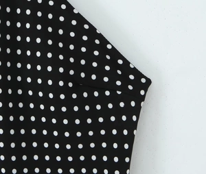 Close-up of black and white polka dot fabric detail on sleeveless backless dress